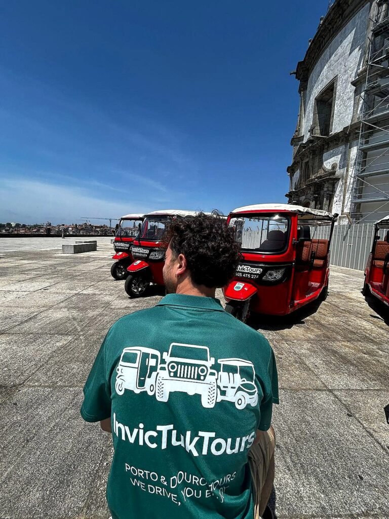 Invictuk Tours guide with the fleet of red electric tuk tuks in Porto