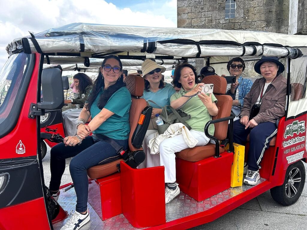 Family group enjoying a Porto city tour by electric tuk tuk