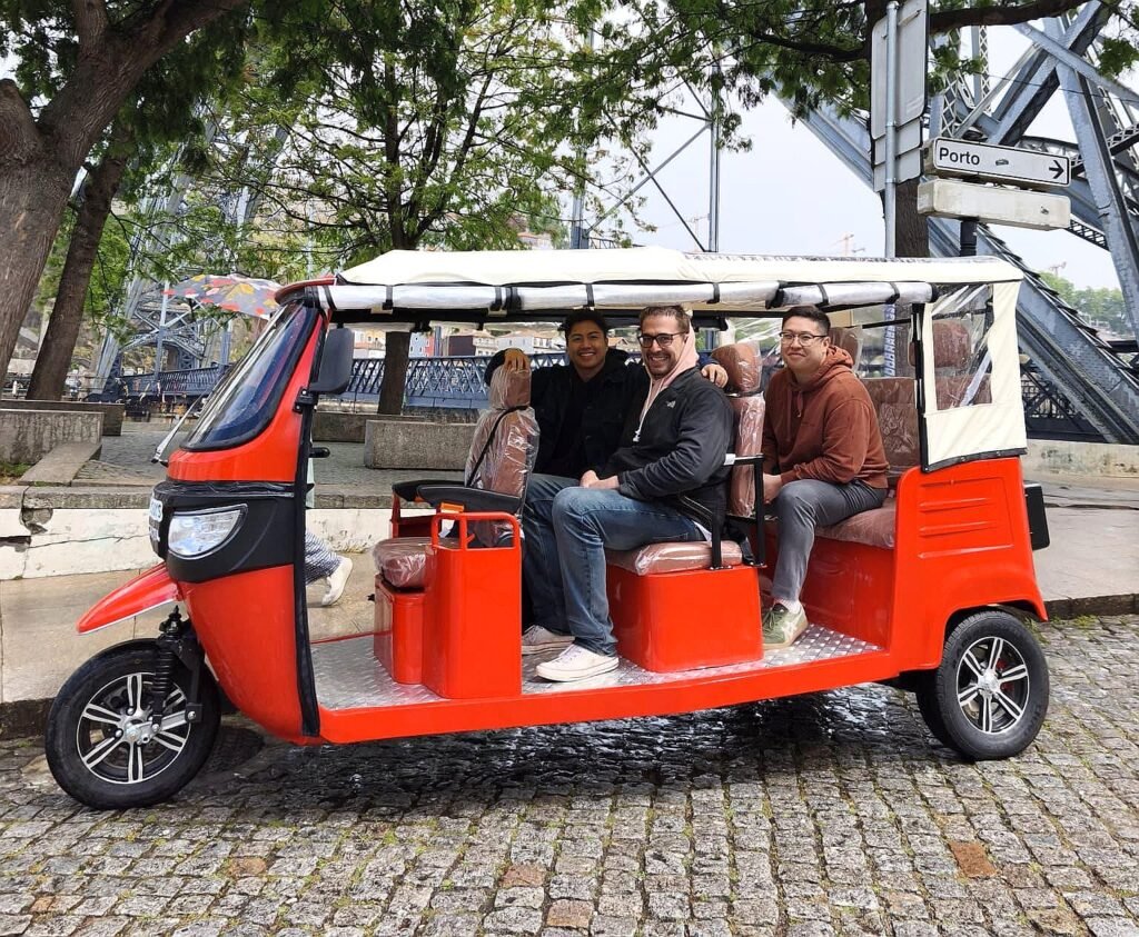 Electric tuk tuk tour beside the Dom Luis I Bridge in Porto
