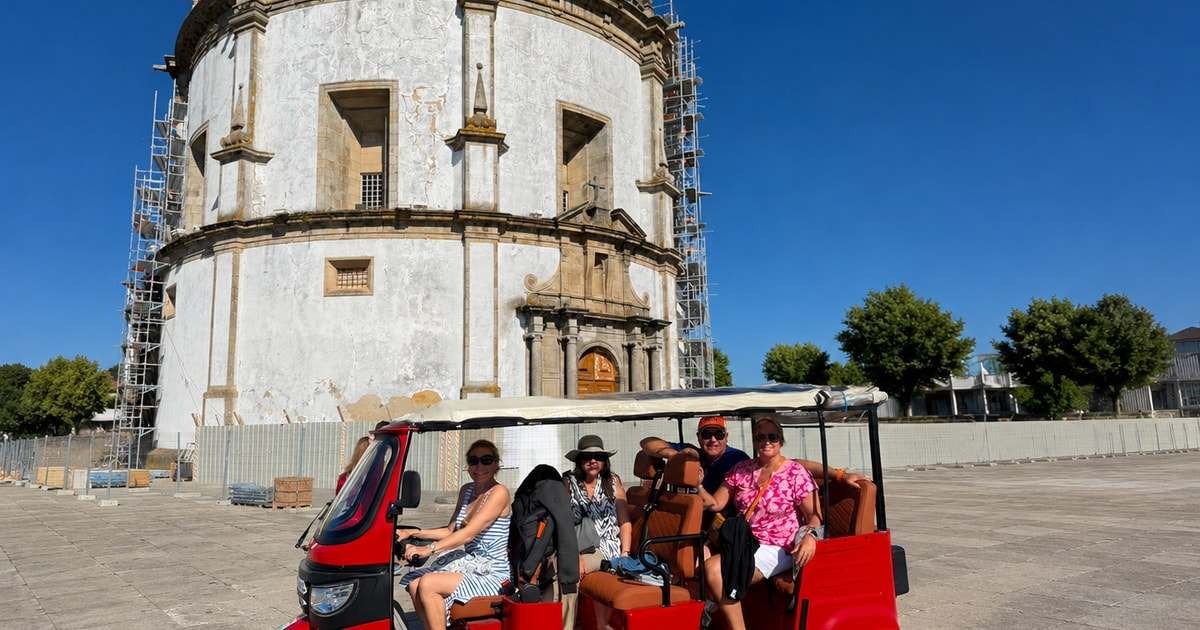 Guests on a red electric tuk-tuk in front of Serra do Pilar monastery, Porto