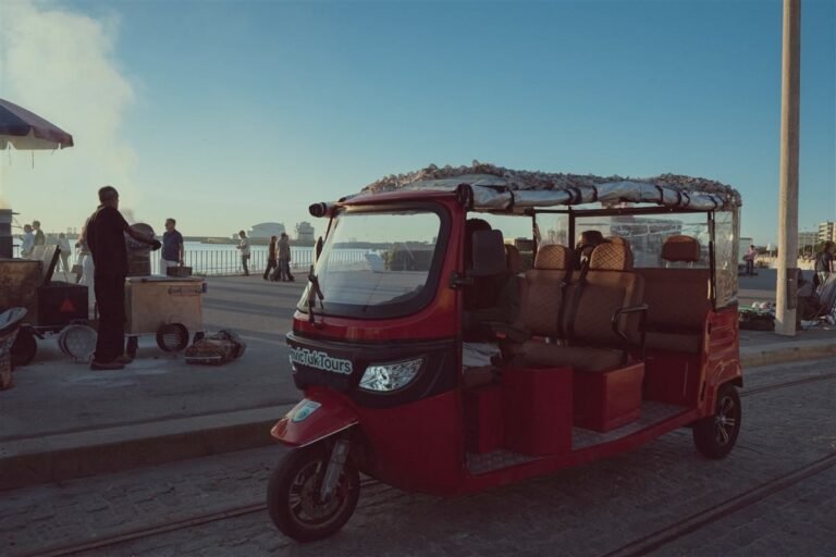 Red electric tuk-tuk on the Atlantic seafront at Foz, Porto