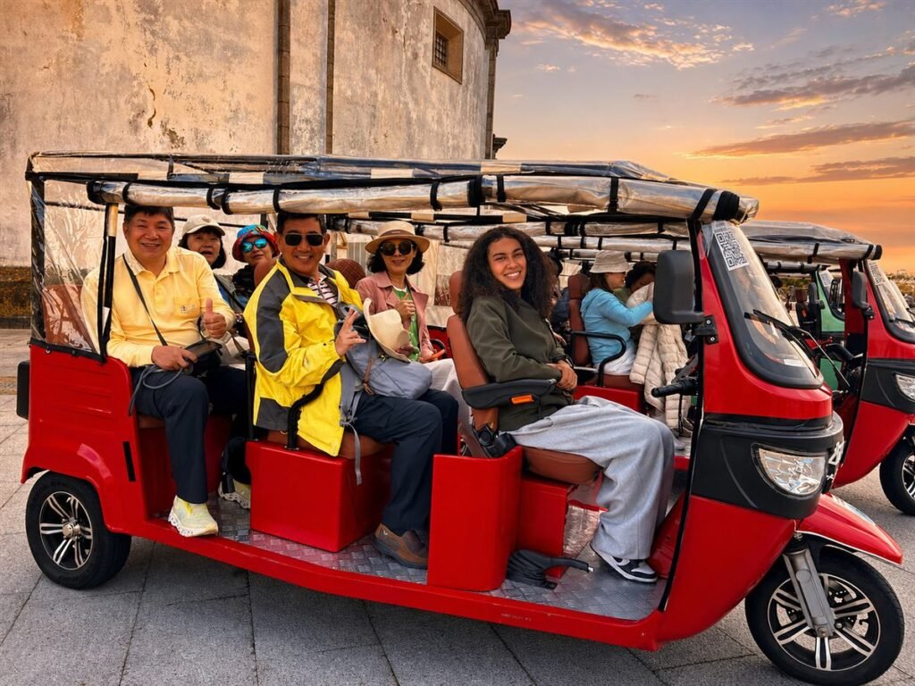 Guests in a private red tuk-tuk at golden hour in Porto